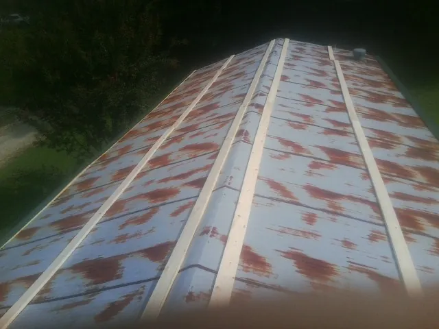 Rusted metal roof panels with new wood purlins before replacement — Storm Damage Roof Repair in Upton by Roofing Brothers