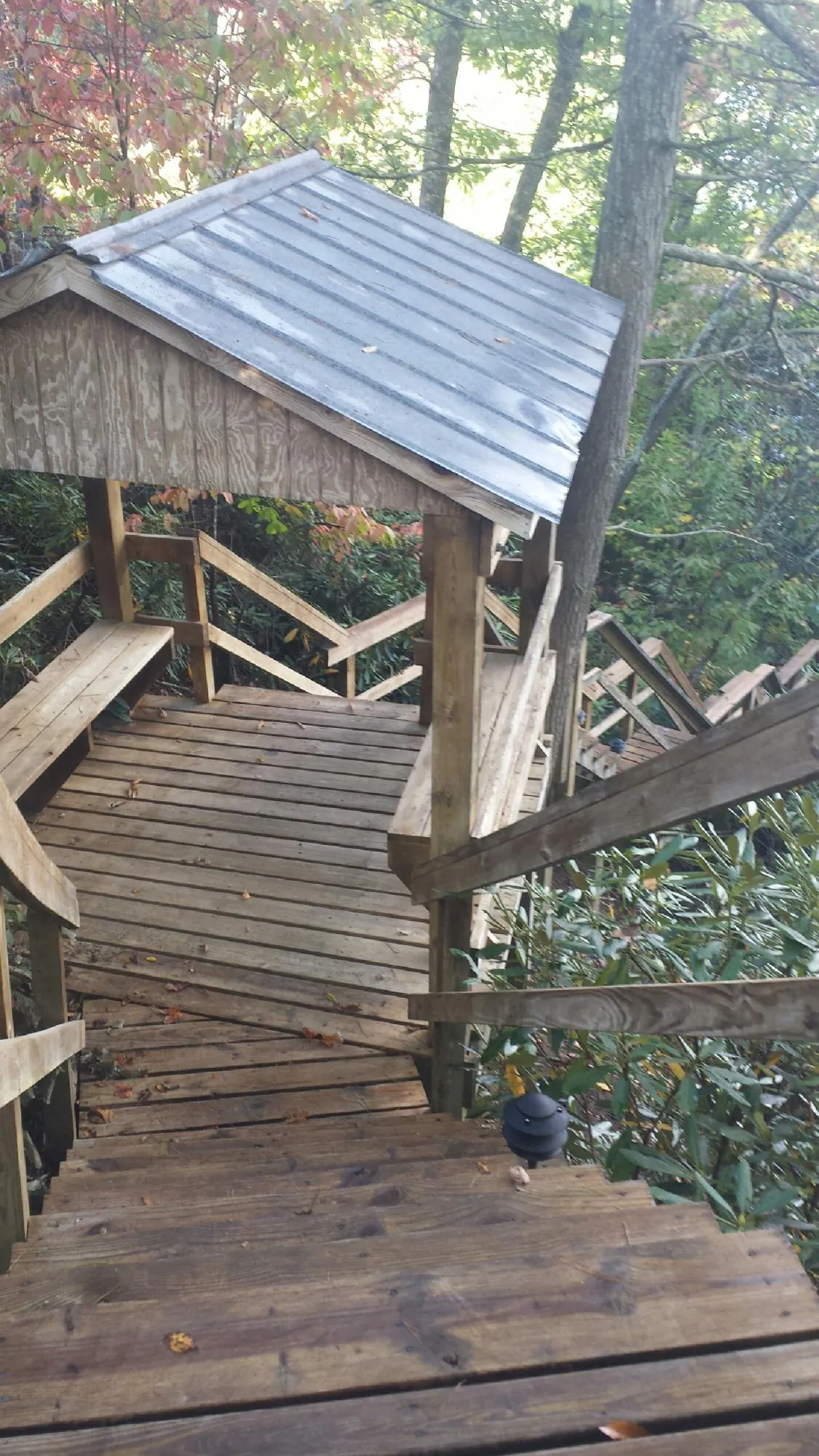 Metal roofed shelter over wooden steps on a wooded walkway — Skylight Repair & Installation work by our crew in Upton